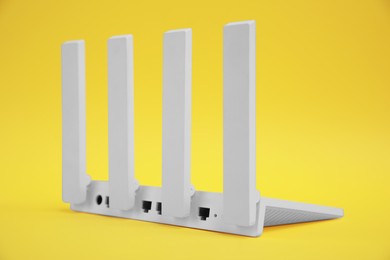 Photo of One modern Wi-Fi router on yellow background