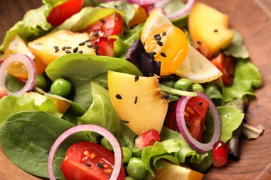 Delicious salad with peach, green peas and vegetables in bowl, closeup