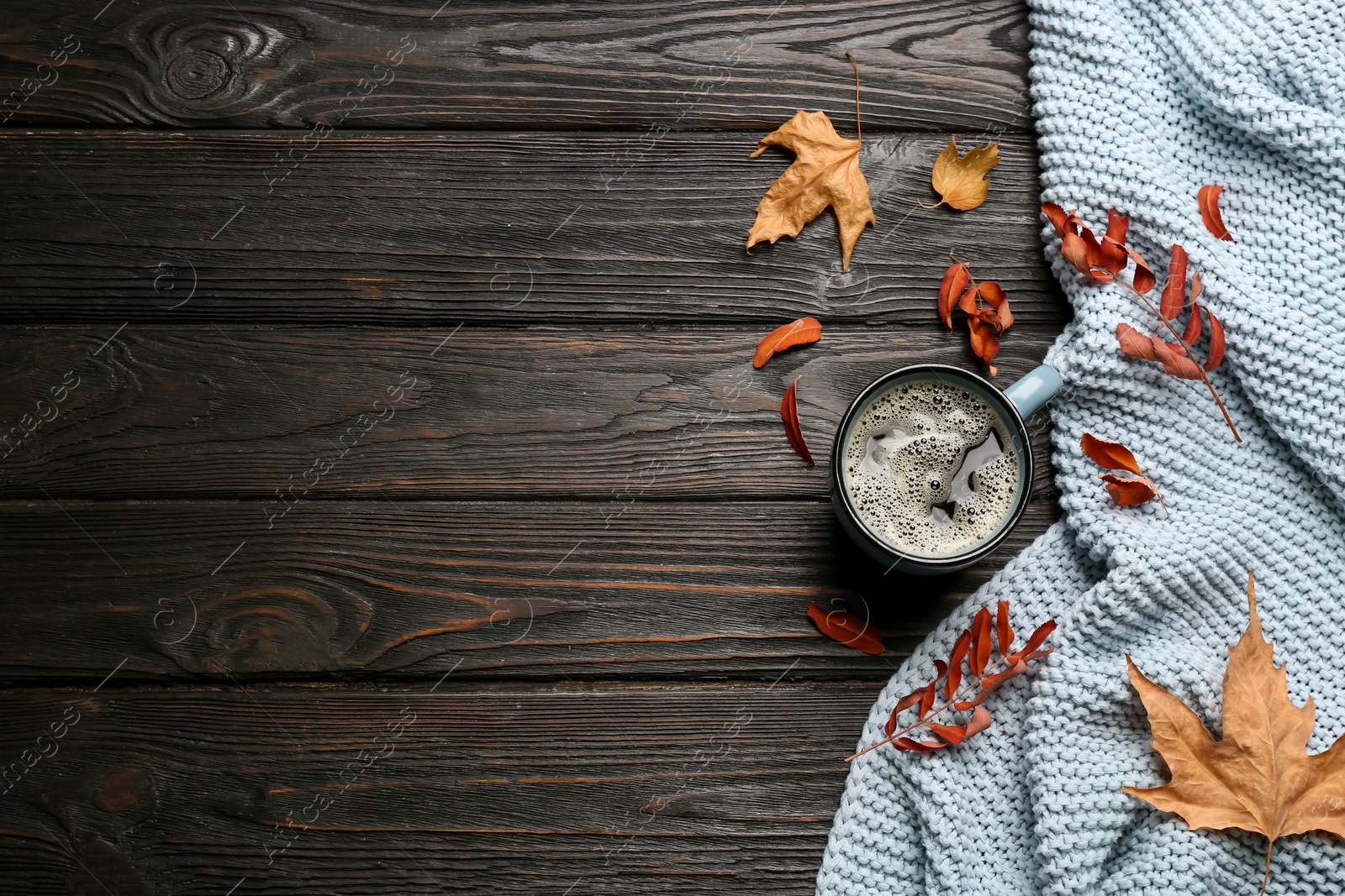 Photo of Flat lay composition with hot drink and warm plaid on black wooden table, space for text