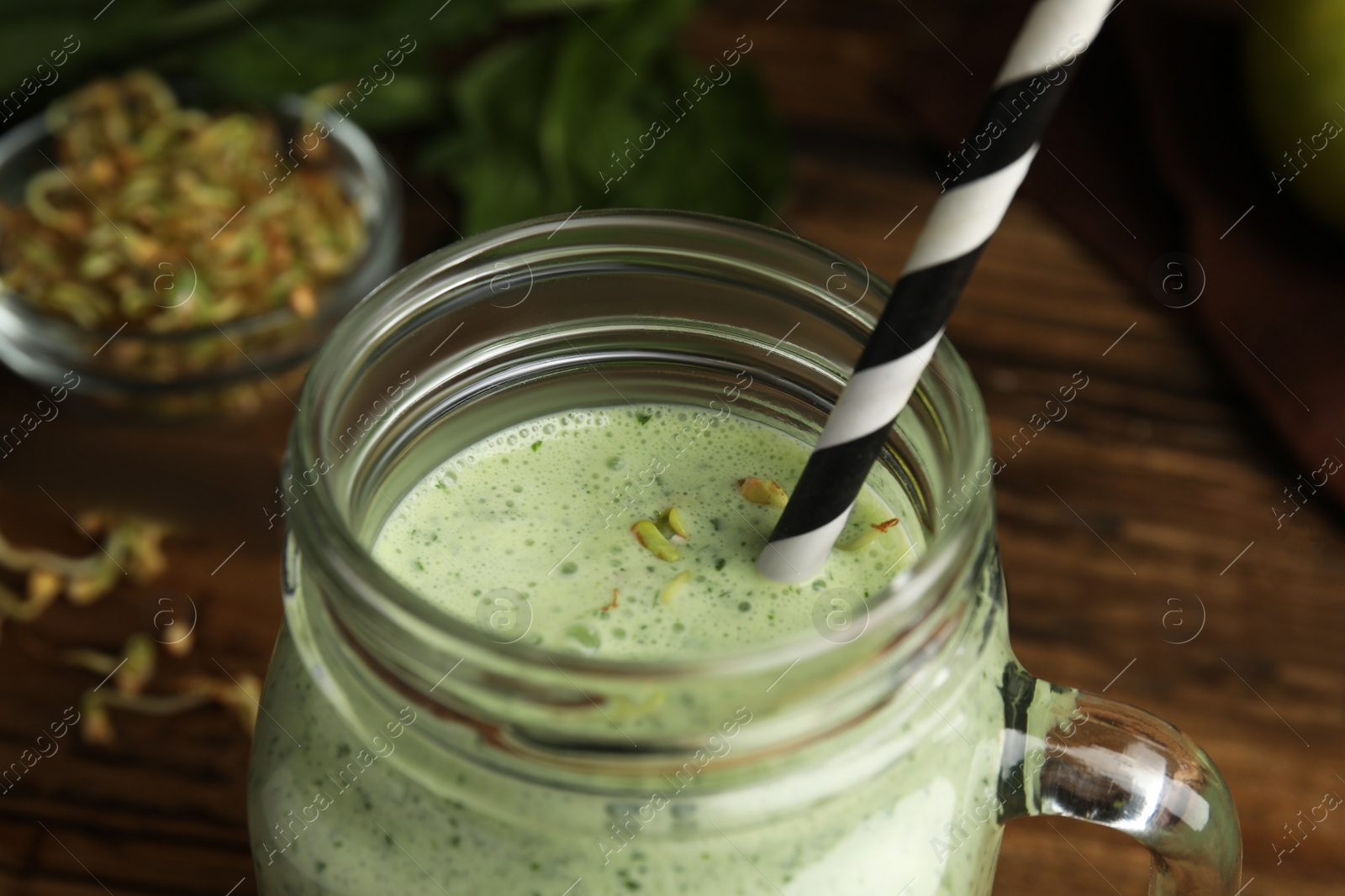 Photo of Green buckwheat smoothie on wooden table, closeup