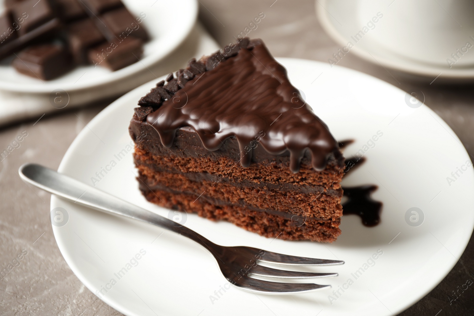 Photo of Tasty chocolate cake served on grey table, closeup