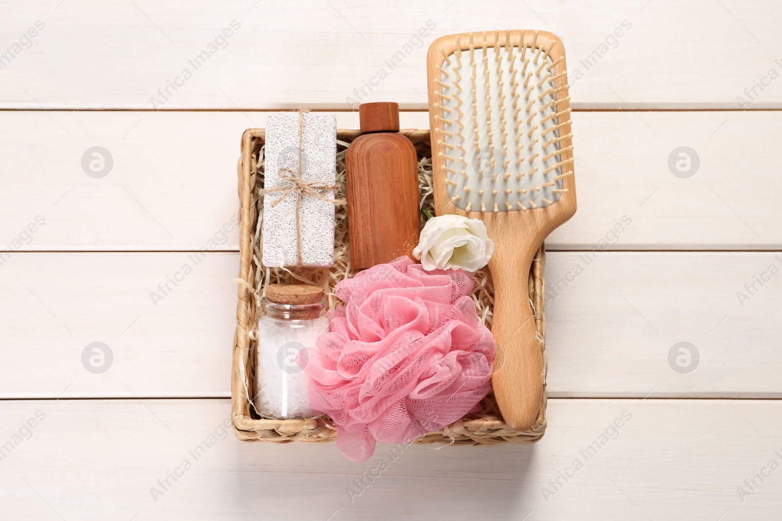 Photo of Spa gift set with different products in wicker box on white wooden table, top view