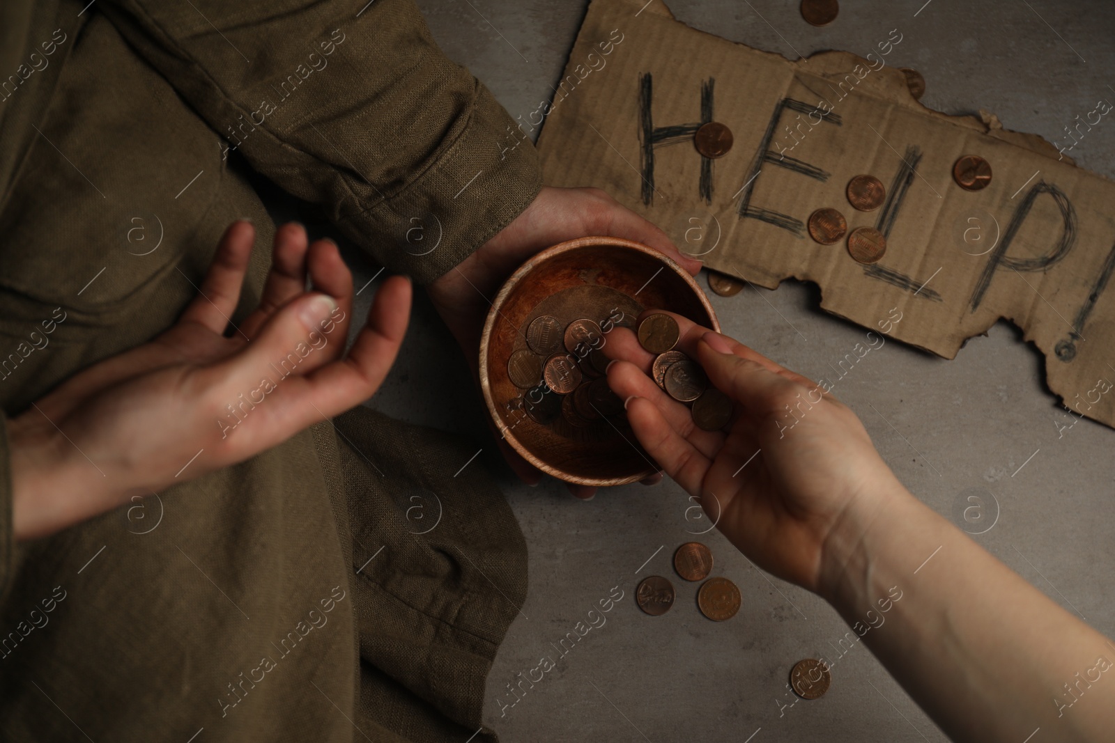 Photo of Woman giving coins to homeless, top view. Charity and donation