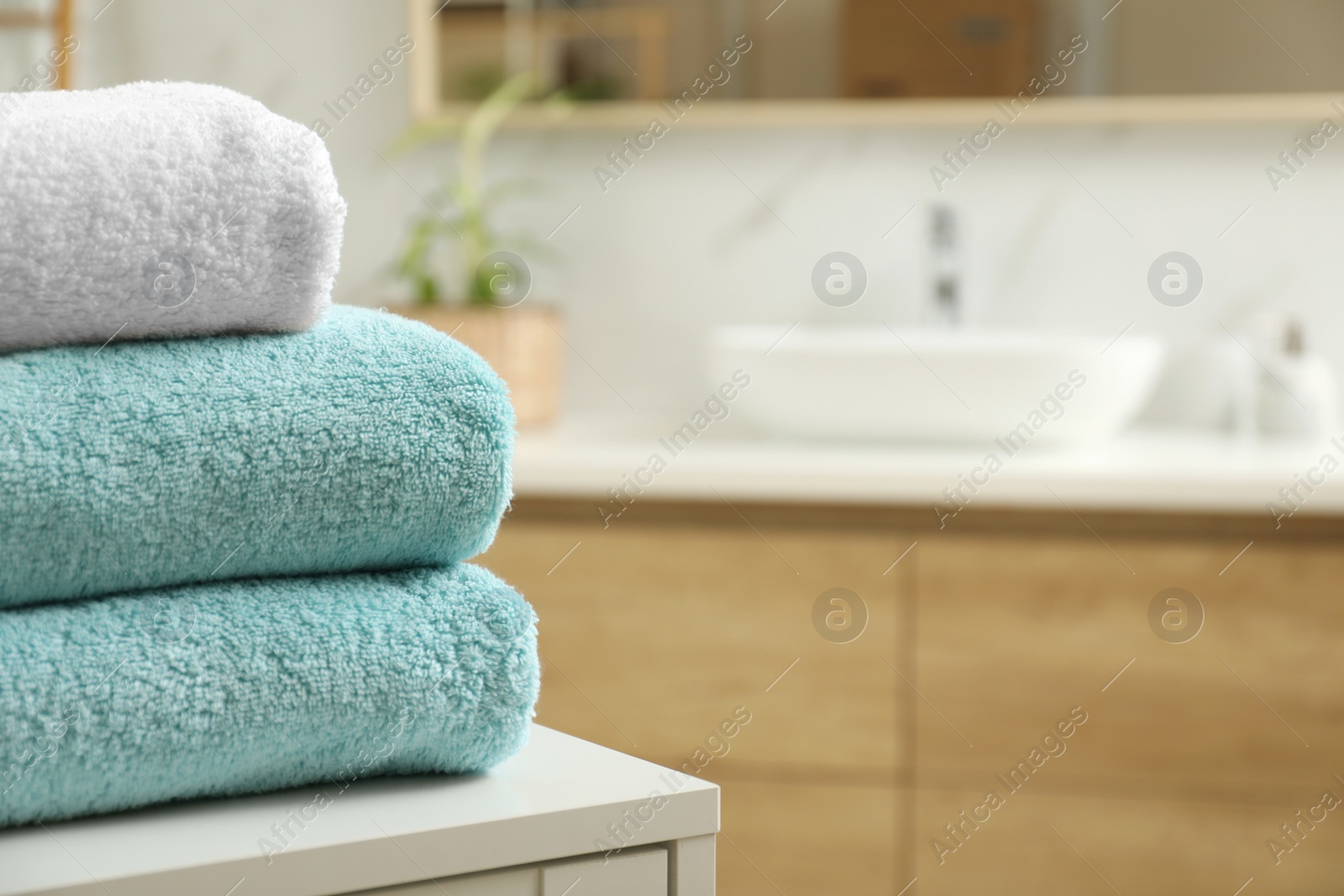 Photo of Stack of clean towels on table indoors. Space for text