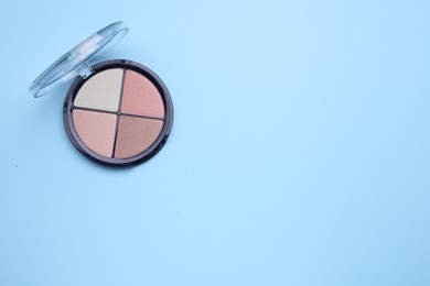 Photo of Contouring palette on light blue background, top view with space for text. Professional cosmetic product