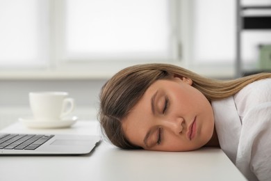 Photo of Tired young woman sleeping at workplace in office