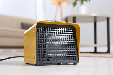 Photo of Modern electric heater on floor at home