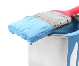 Photo of Can of light blue paint and brush on white background, closeup