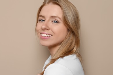 Portrait of beautiful young woman on beige background