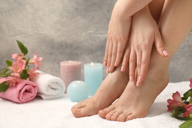 Woman with neat toenails after pedicure procedure on white terry towel, closeup