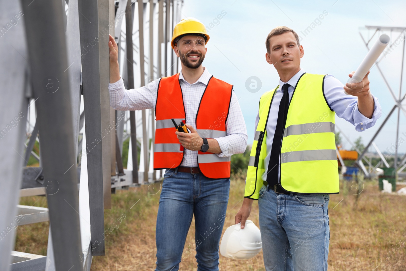 Photo of Professional engineers working on installation of electrical substation outdoors