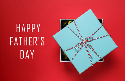 Image of Beautiful gift box and phrase HAPPY FATHER'S DAY on red background, top view