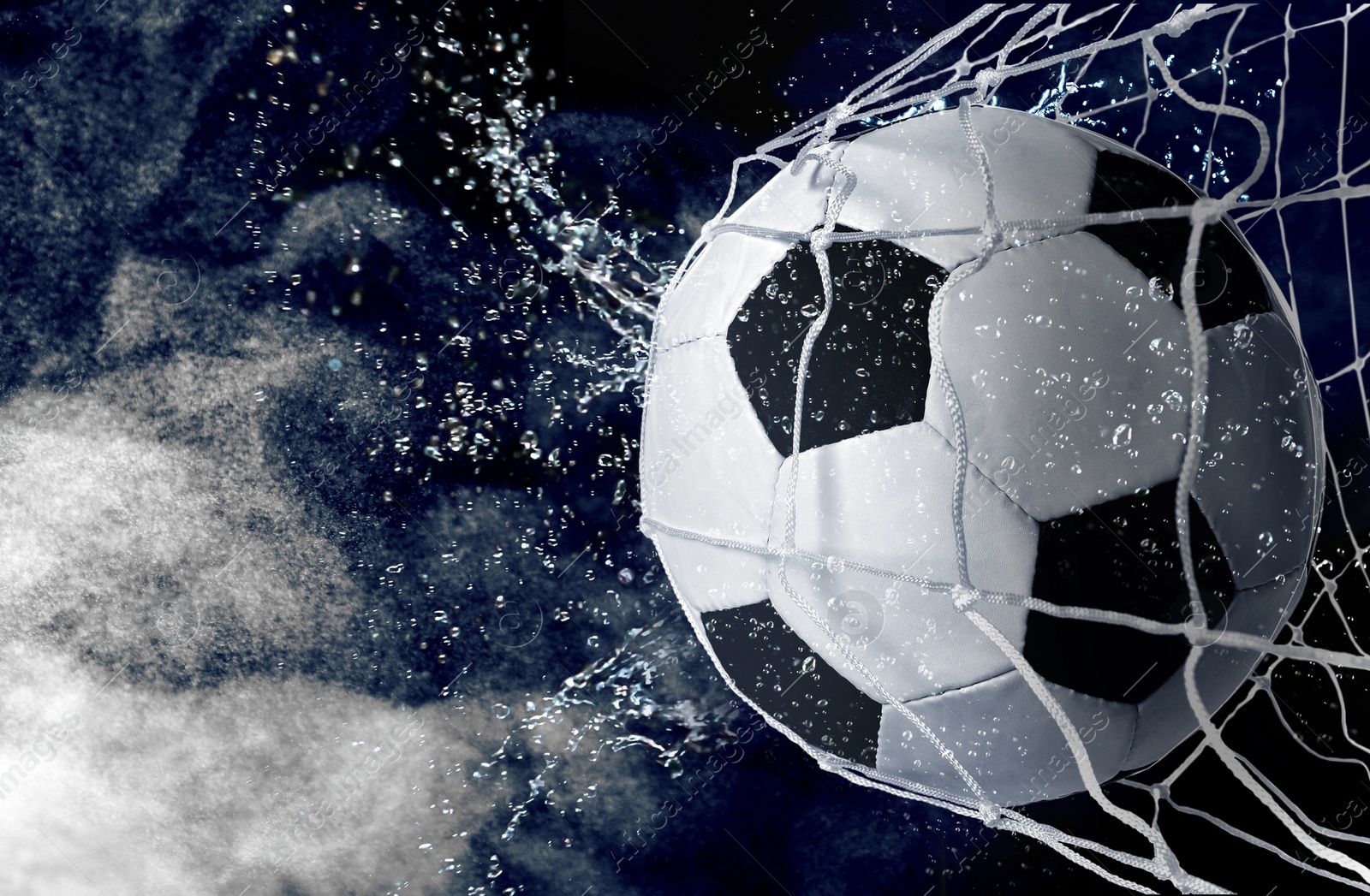 Image of Soccer ball in net with splash water and white smoke against dark background