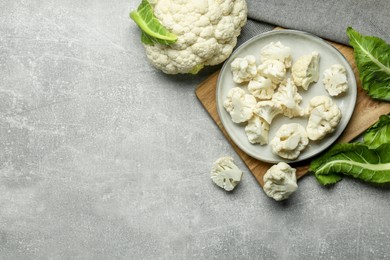 Photo of Cut and whole cauliflowers on grey table, flat lay. Space for text