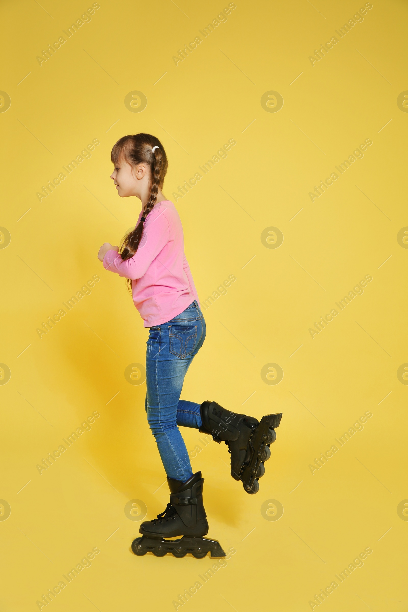 Photo of Girl with inline roller skates on color background