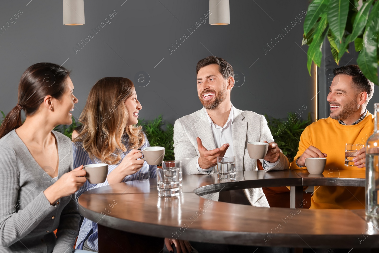 Photo of Friends with drinks spending time together in cafe