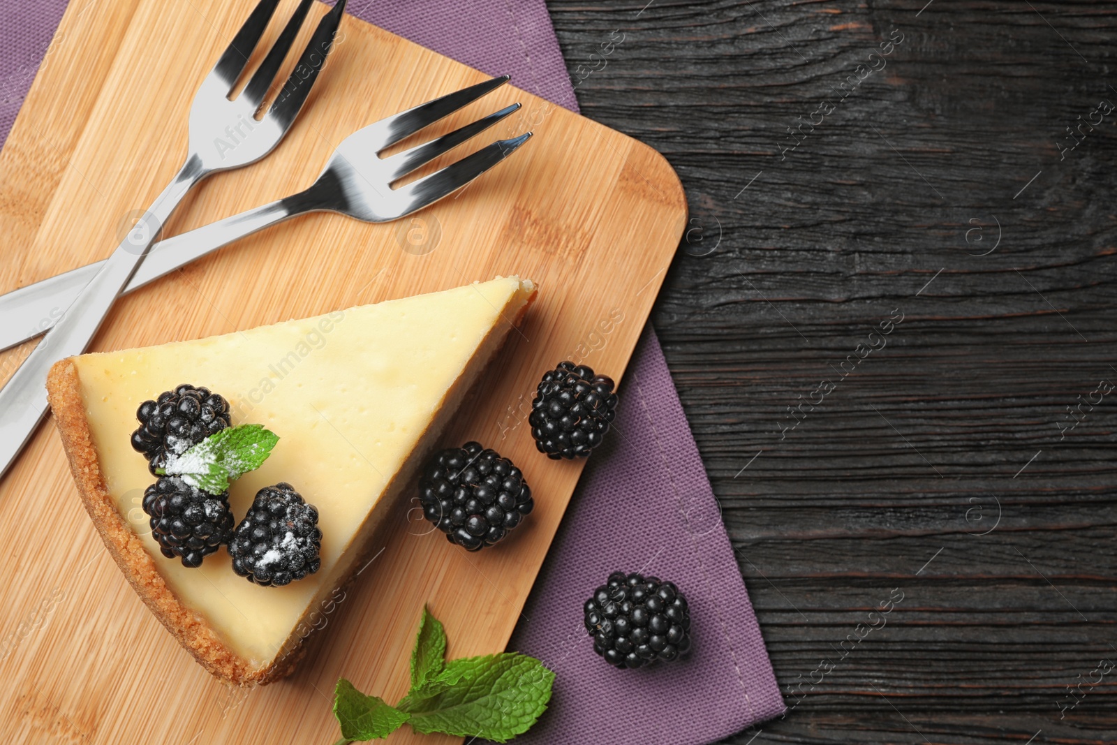 Photo of Piece of delicious cheesecake with blackberries on dark wooden background, flat lay. Space for text