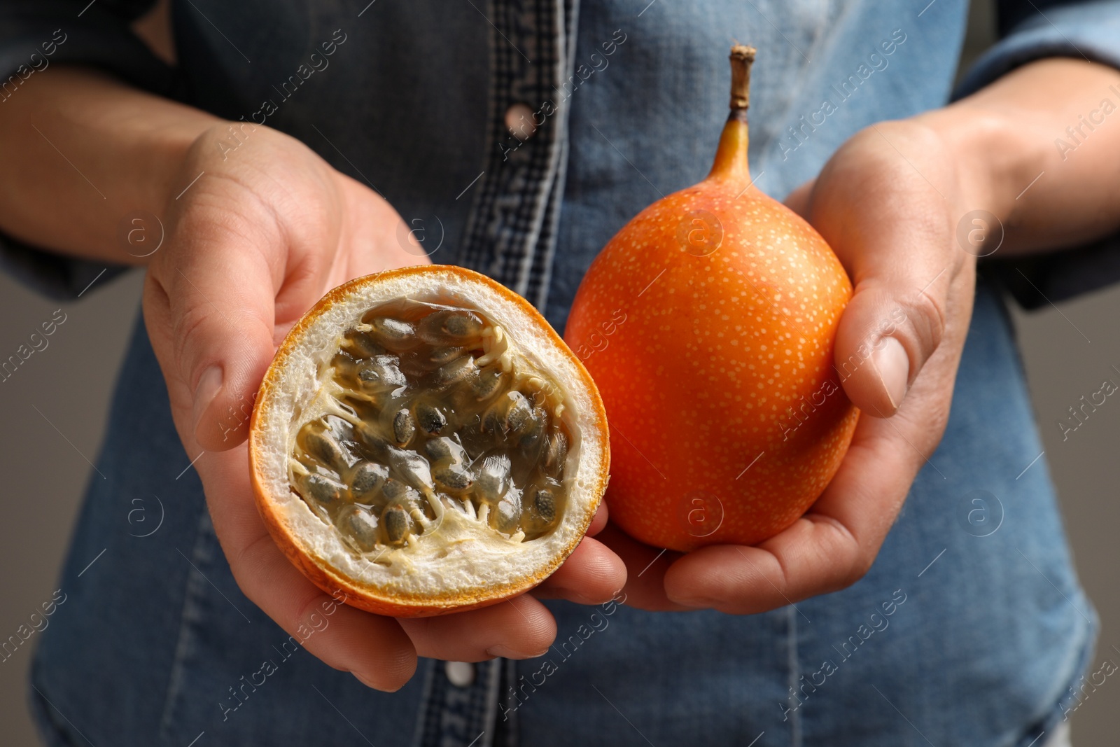 Photo of Woman with ripe granadillas, closeup. Exotic fruit