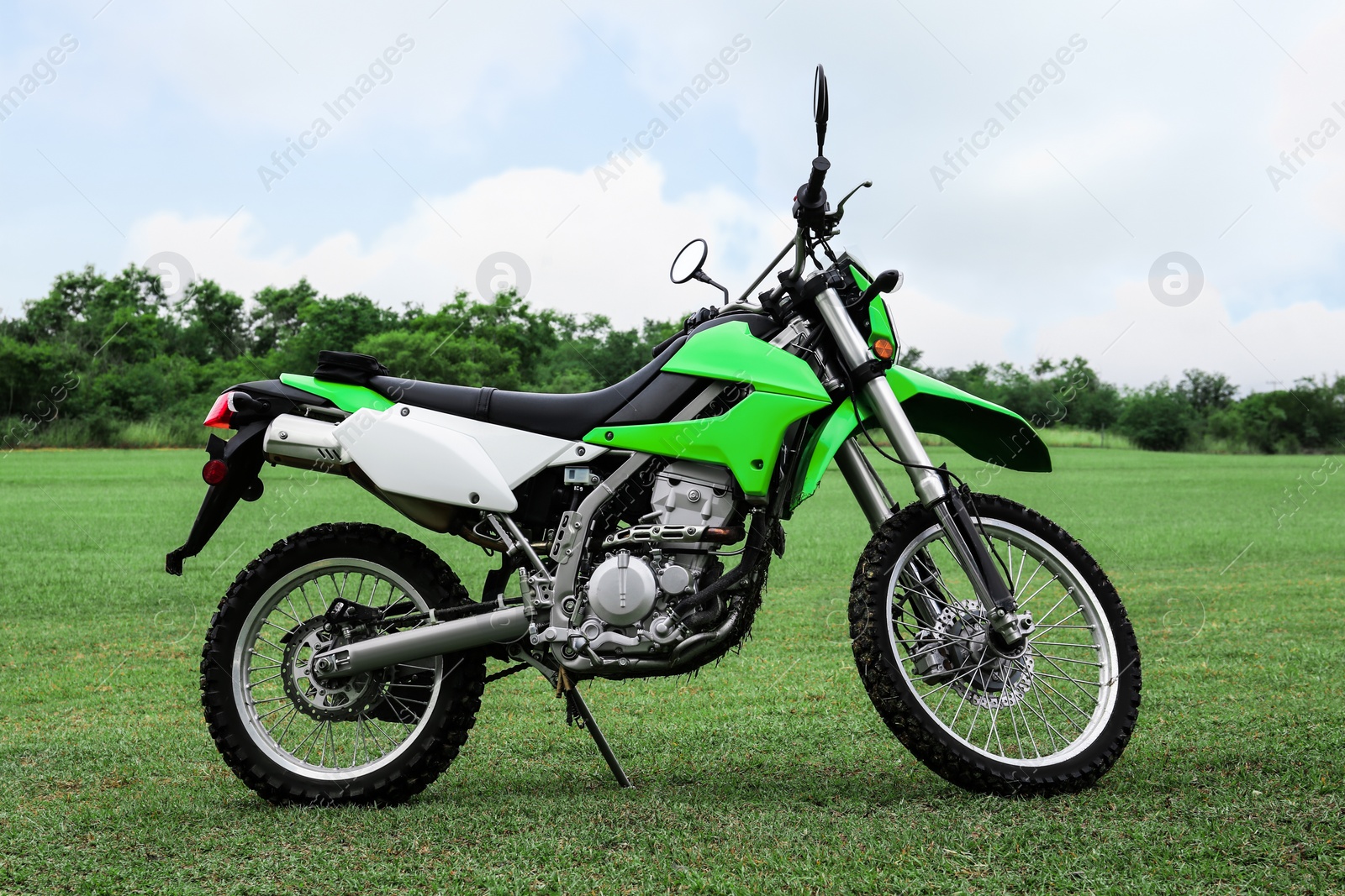 Photo of Stylish cross motorcycle on green grass outdoors