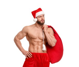 Muscular young man in Santa hat holding bag with presents on white background