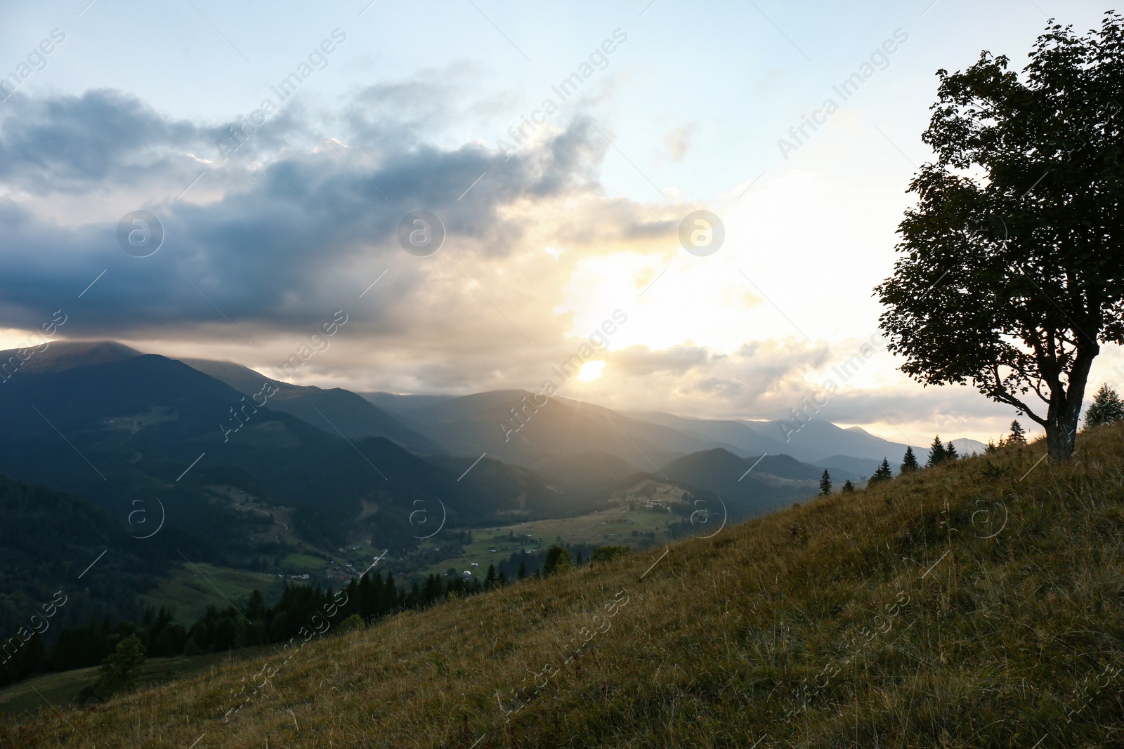 Photo of Beautiful mountains under cloudy sky at sunset. Picturesque landscape