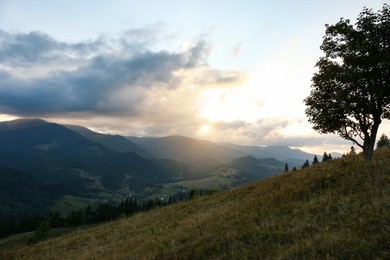 Photo of Beautiful mountains under cloudy sky at sunset. Picturesque landscape