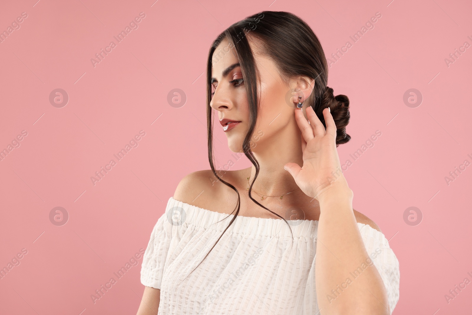 Photo of Beautiful woman with elegant jewelry on pink background