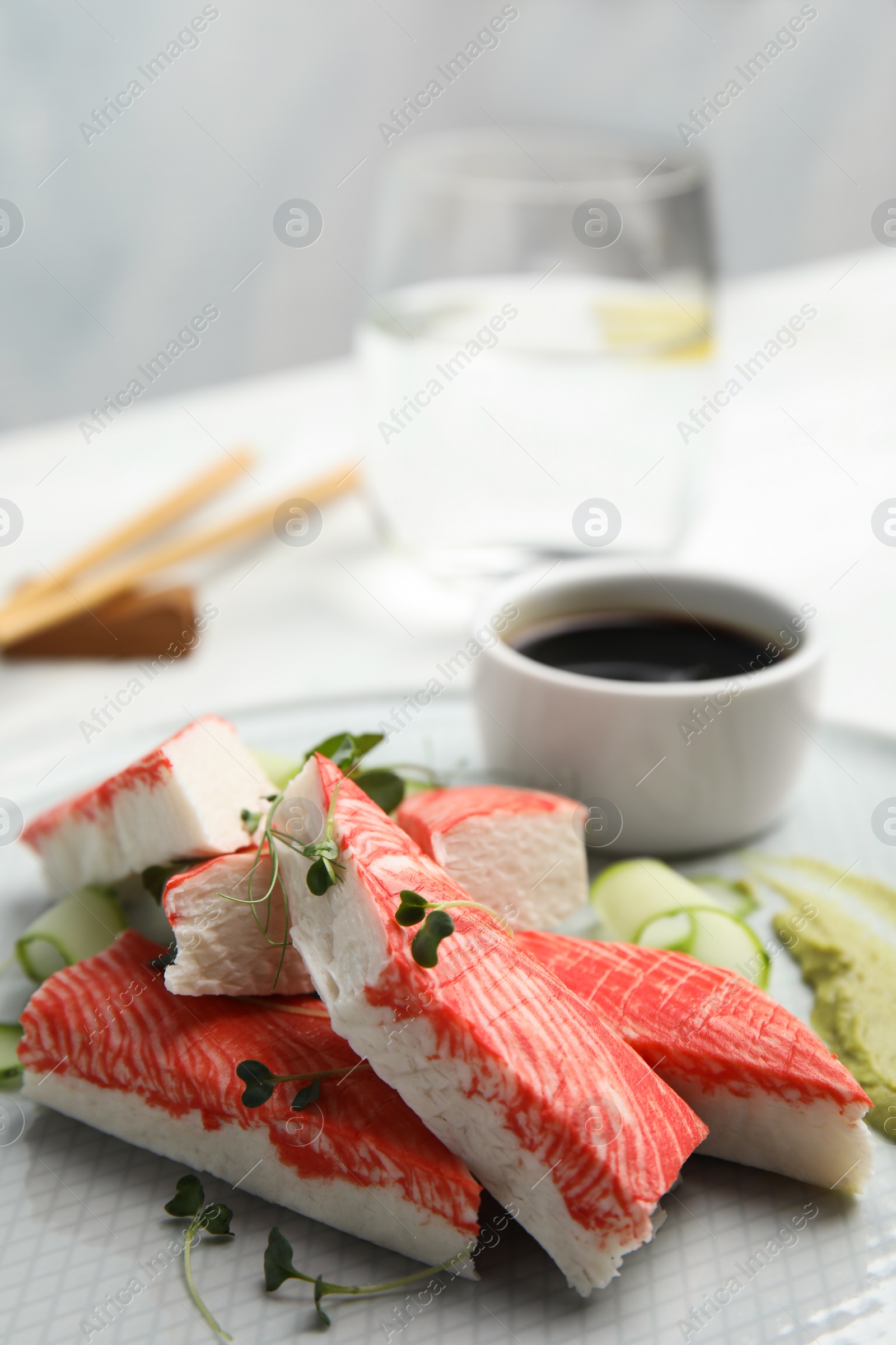 Photo of Fresh crab sticks with cucumber on plate, closeup. Space for text