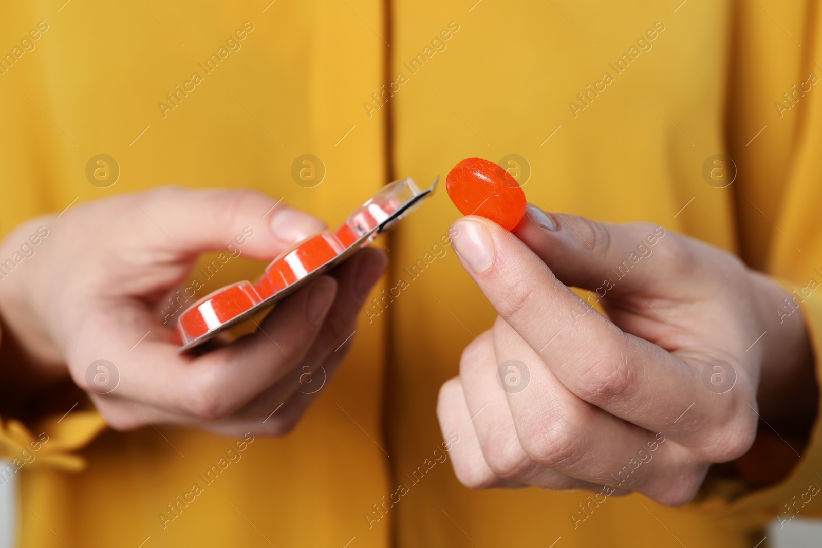 Photo of Woman taking cough drop from blister, closeup