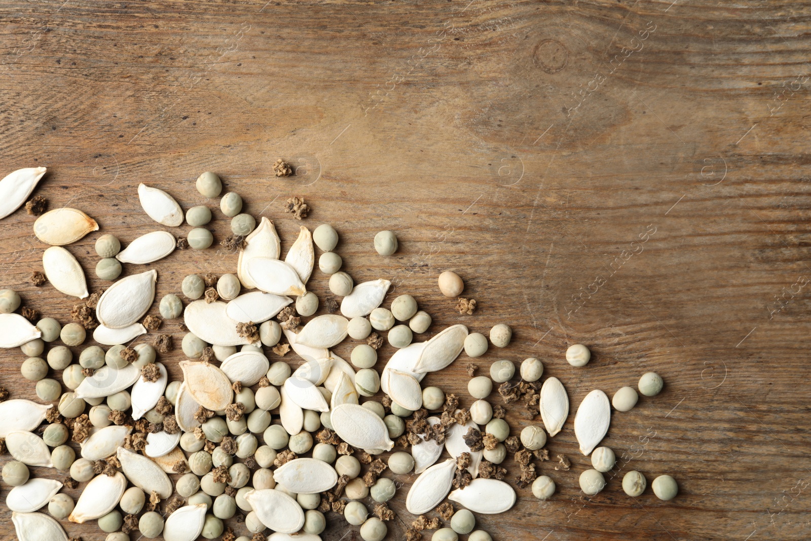 Photo of Mixed vegetable seeds on wooden background, flat lay. Space for text