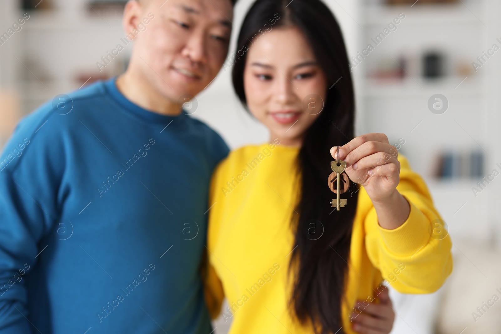 Photo of Happy couple with key in their new apartment, selective focus