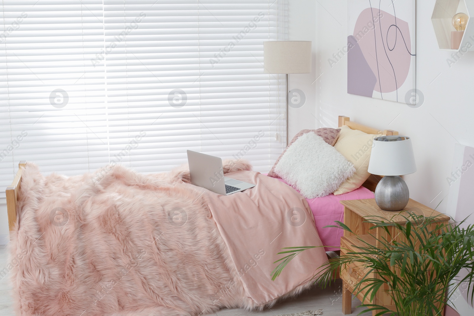 Photo of Stylish teenager's room interior with comfortable bed and laptop