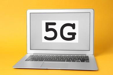 Photo of Internet concept. Laptop with 5G card on yellow background