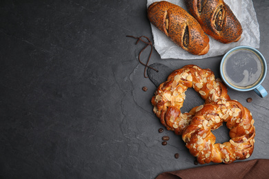 Delicious pastries and coffee on black table, flat lay. Space for text