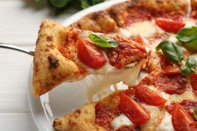 Photo of Taking piece of delicious Margherita pizza at white table, closeup