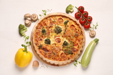 Photo of Delicious homemade vegetable quiche and ingredients on white wooden table, flat lay