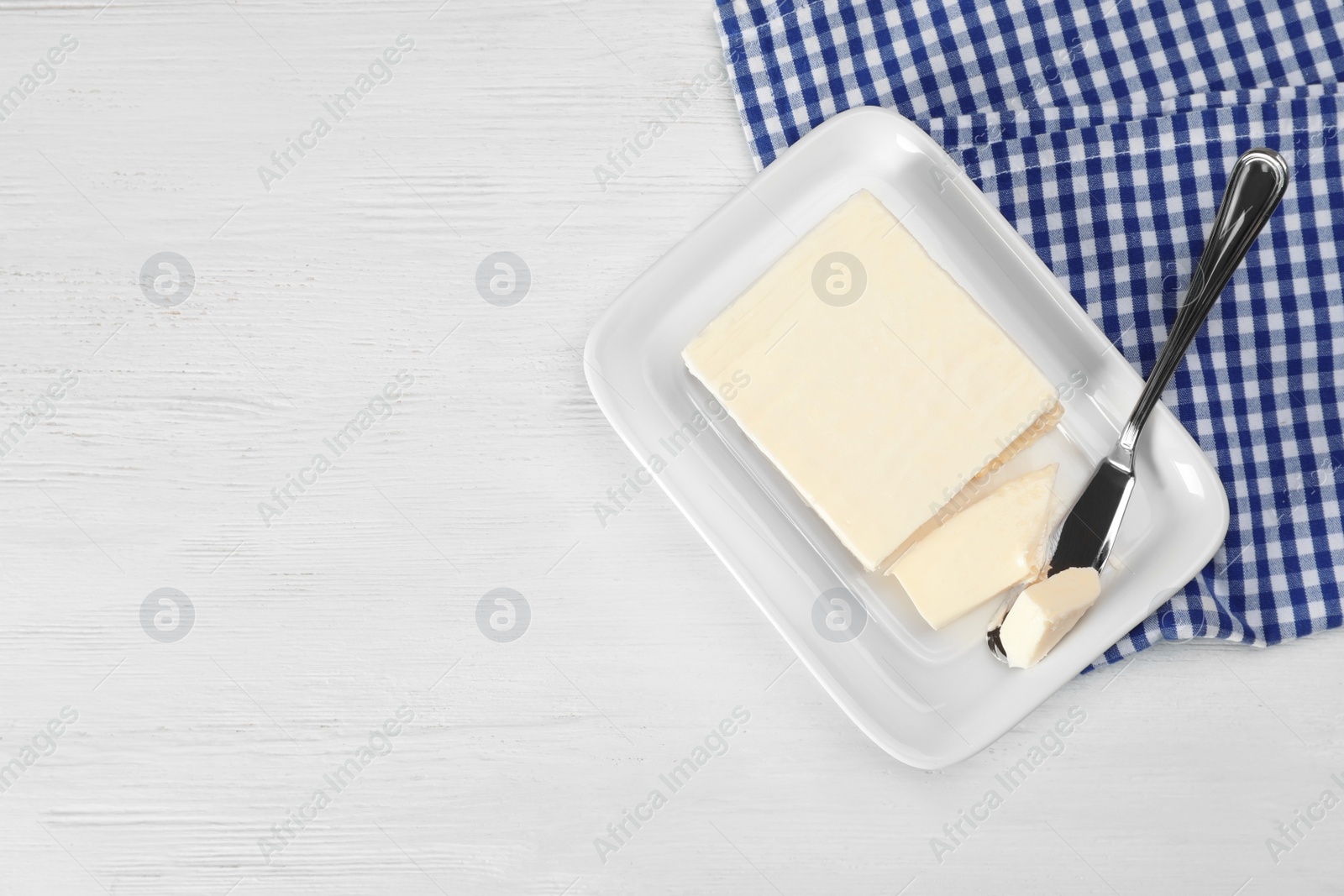 Photo of Plate with tasty fresh butter and knife on table, top view