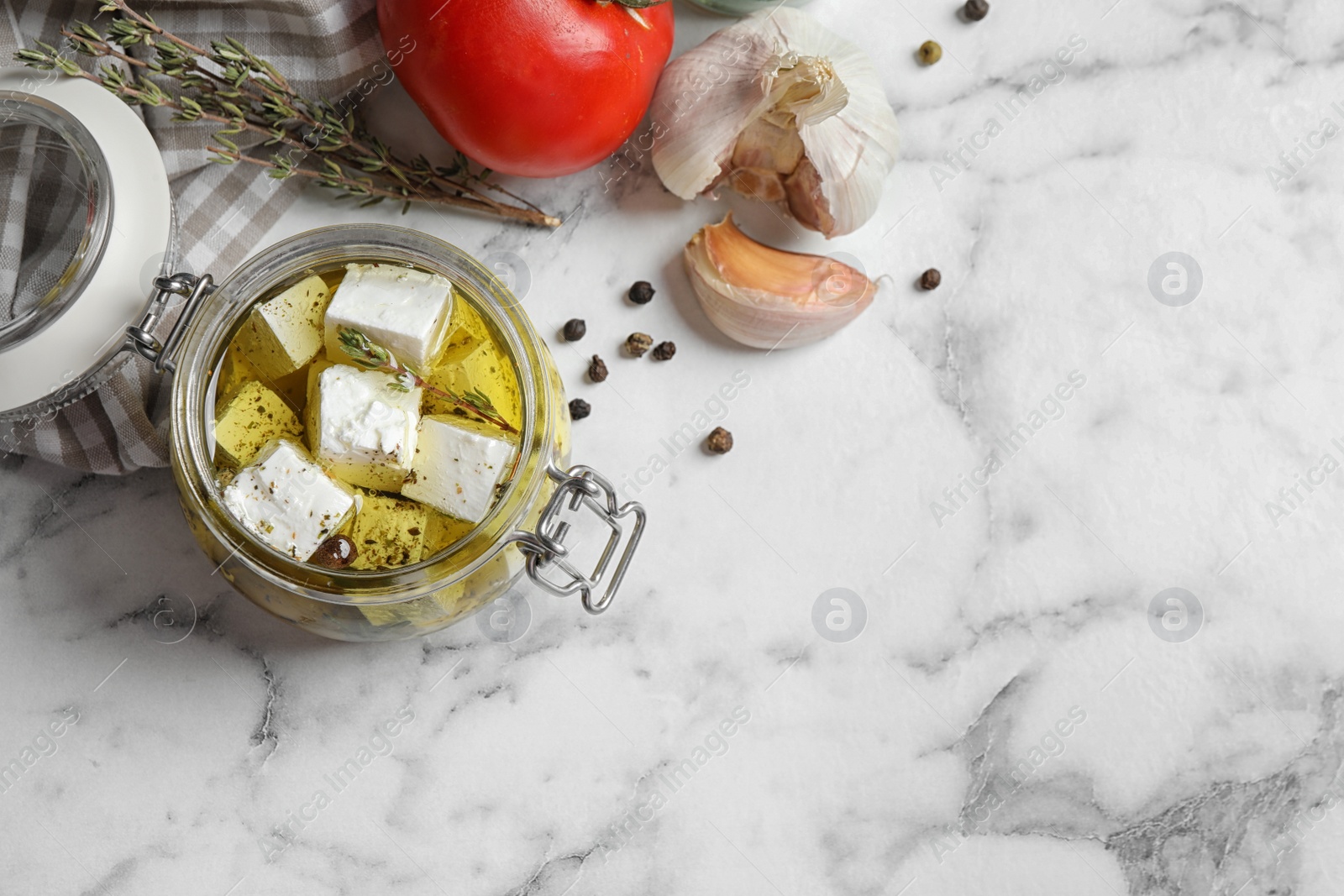 Photo of Flat lay composition with pickled feta cheese in jar on white marble table. Space for text