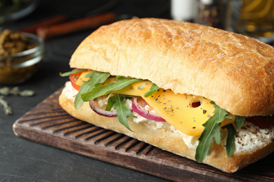 Delicious sandwich with fresh vegetables and cheese on grey table, closeup