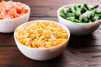 Photo of Different tasty frozen vegetables on wooden table