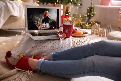 Photo of MYKOLAIV, UKRAINE - DECEMBER 25, 2020: Woman watching The Queen's Gambit series on laptop at home, closeup. Cozy winter holidays atmosphere