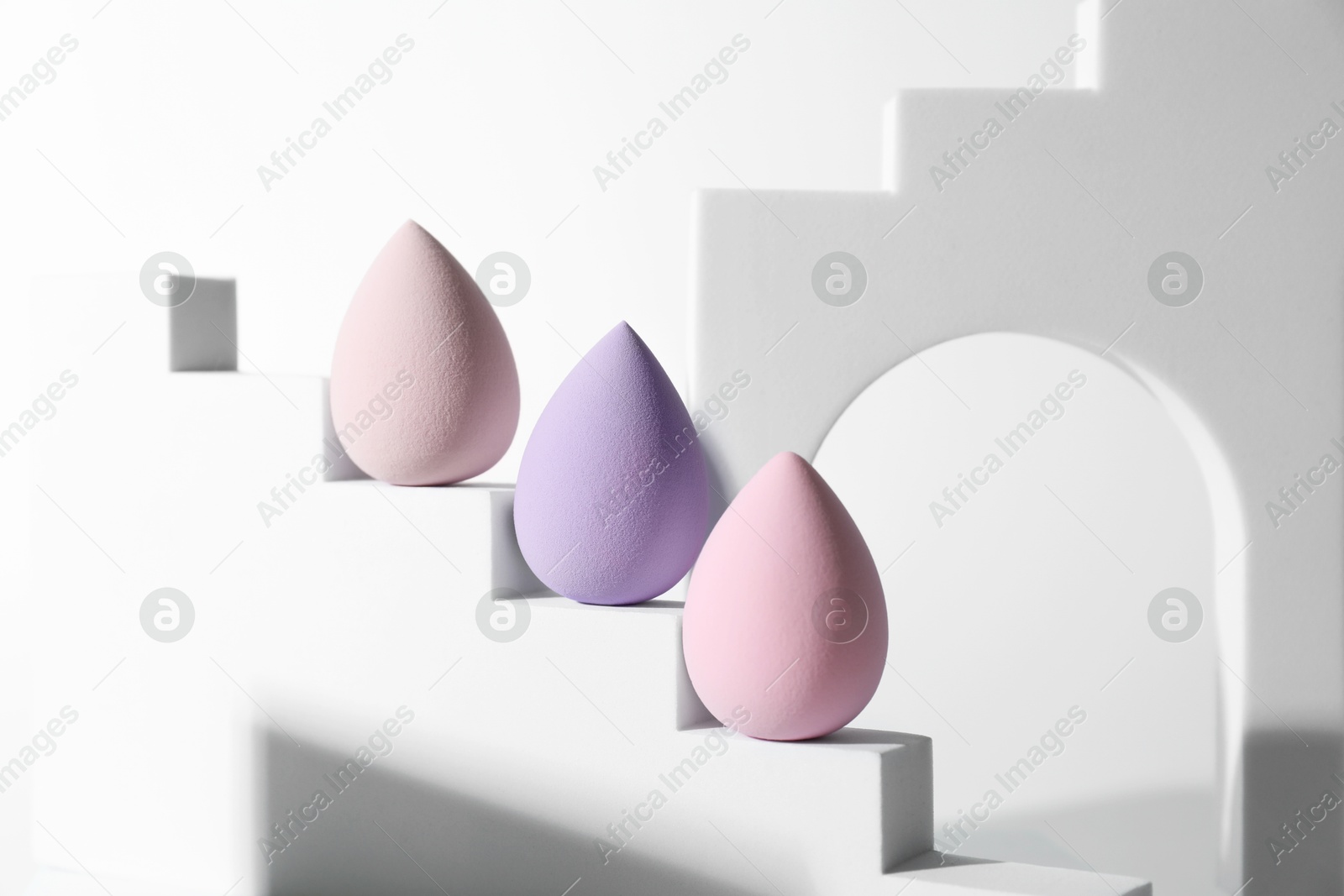 Photo of Stylish presentation of makeup sponges on white background