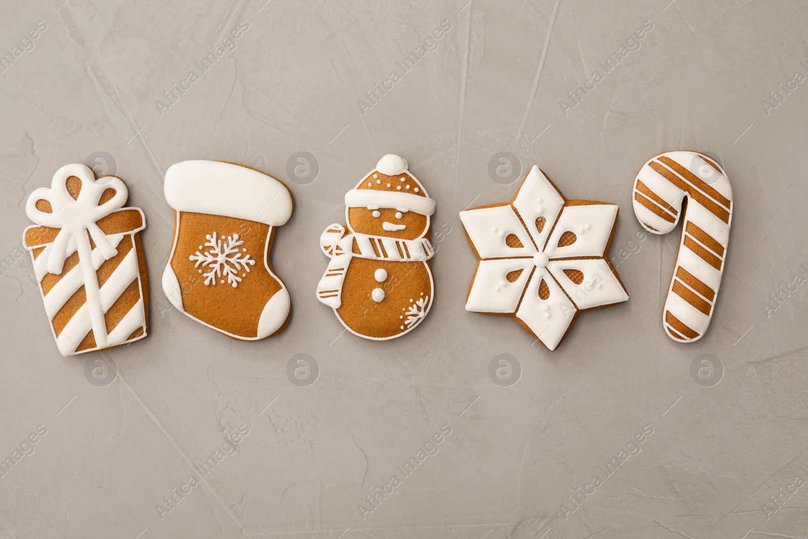 Photo of Different Christmas gingerbread cookies on grey background, flat lay