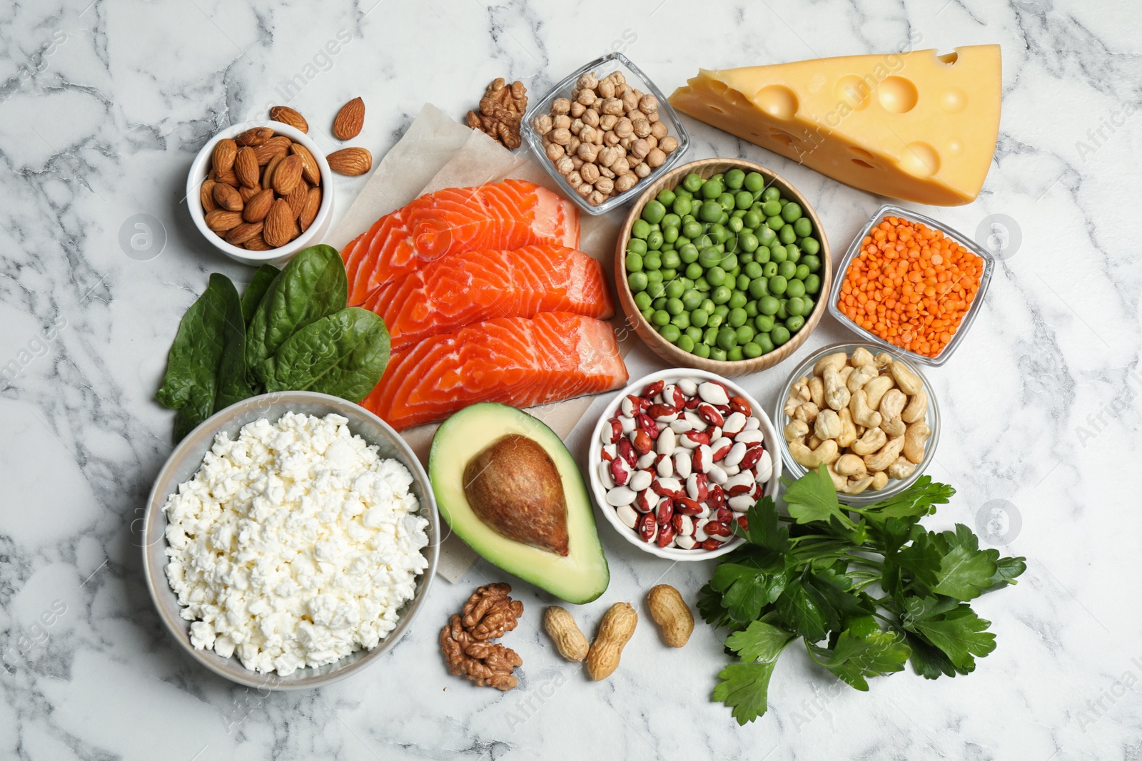 Photo of Products rich in protein on white marble table, flat lay