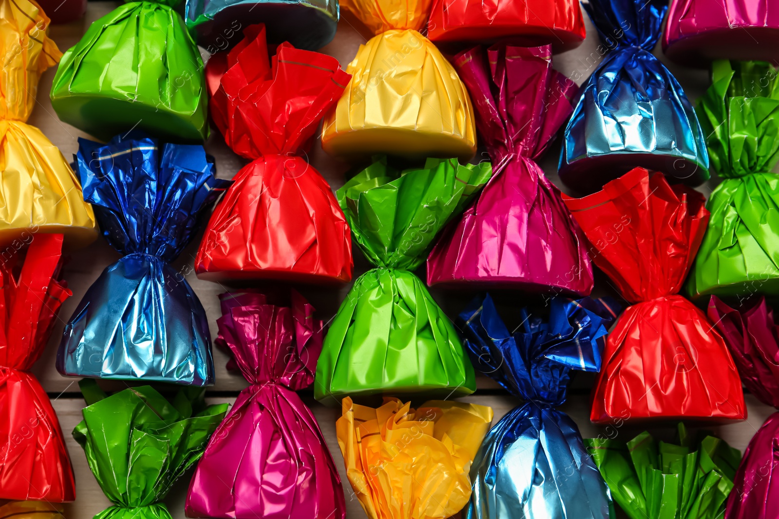 Photo of Candies in colorful wrappers as background, closeup