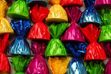 Candies in colorful wrappers as background, closeup