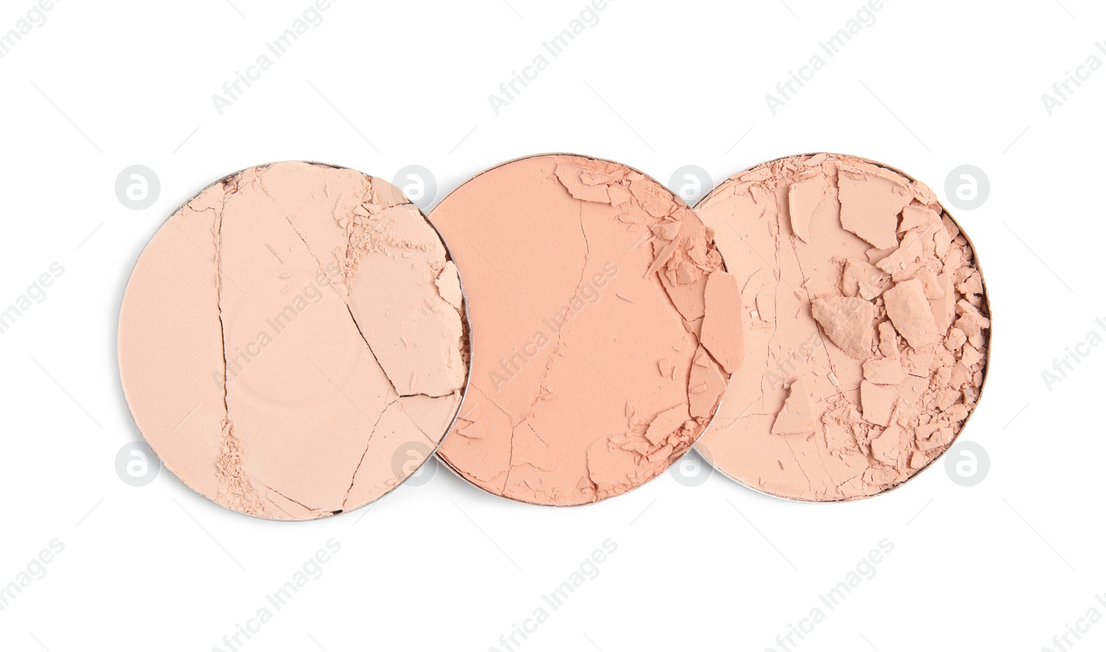 Photo of Different broken face powders on white background, top view