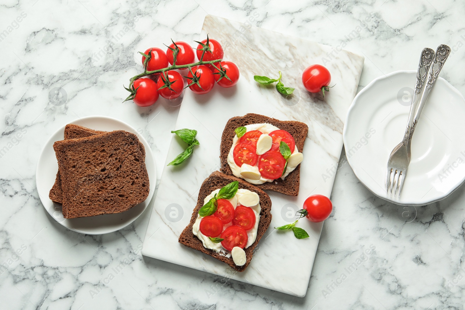 Photo of Flat lay composition with toast bread, cherry tomatoes and basil on marble background