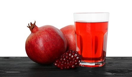 Photo of Refreshing pomegranate juice in glass, seeds and fruits on black wooden table against white background