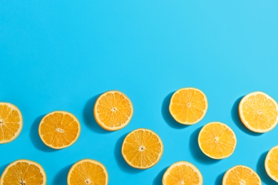 Photo of Slices of delicious oranges on light blue background, flat lay. Space for text
